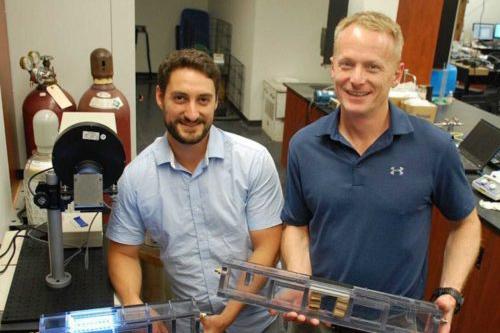 image of Prof. Bill Van Heyst (right) holding SmogStop technology beside postdoc David Wood (left)