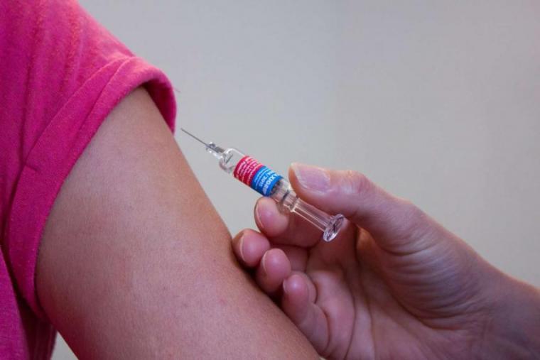 Image of vaccine needle next to child's arm