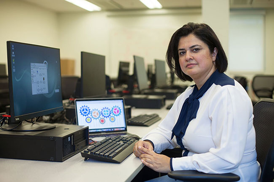 Dr. Rozita Dara sitting at a computer in a computer lab.