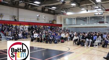 Hundreds of Students gathered for Battle STEM awards ceremony in the W.F. Mitchell Athletics Centre, Mitchell Gym, with the Battle STEM Logo graphic with a white background in the bottom left