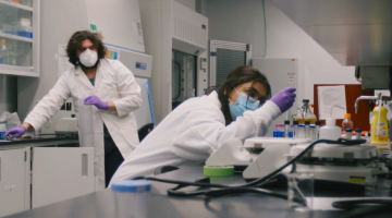 Two students in a lab working with equipment