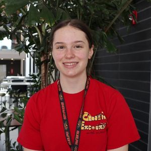 Elena Gogic smiling in a red Creative Encounters shirt.