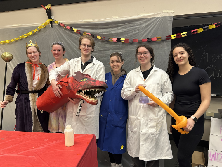 Chem Club members apart of the Wizards of the King's Court Show pose with the paper mache dragon.