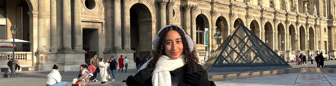 Student standing in front of the Louvre, Paris, France