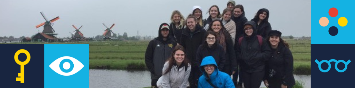 Students gathered for a group picture infront of three windmills