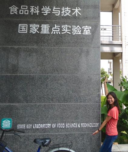 photo of student posing at host university sign