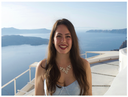 A student smiling with the ocean in the background