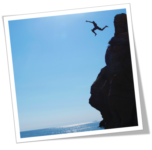 Person jumping off a cliff into water