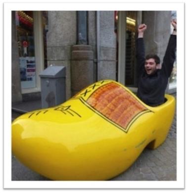 Studen sitting in a large wooden shoe