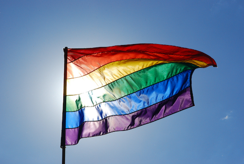 LGBTQ+ rainbow Pride Flag flying on a flag pole
