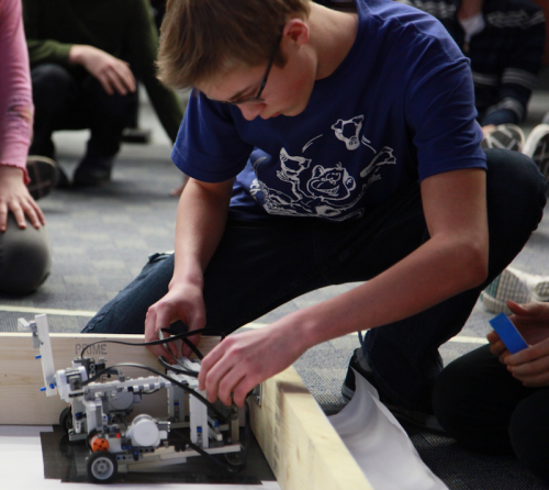 Male student handling robot