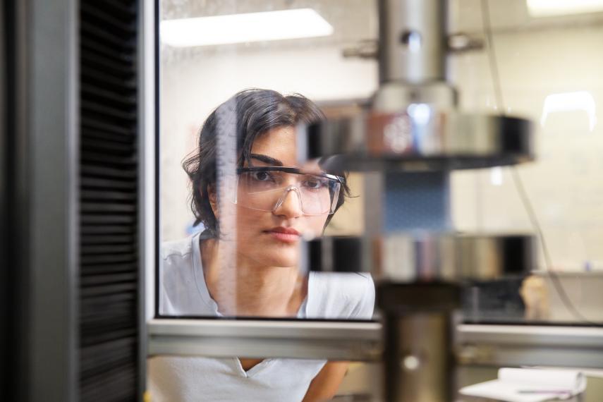 student looks through a press machine