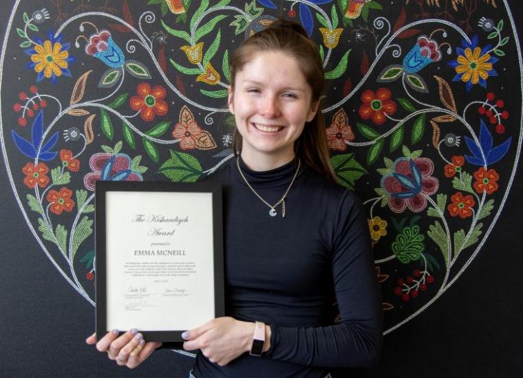 Emma McNeill holding award certificate