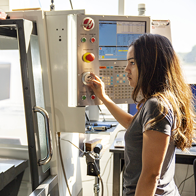 female student using CNC machine