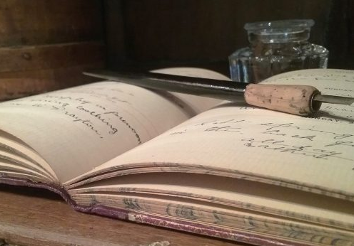 image of a historic diary with a pen