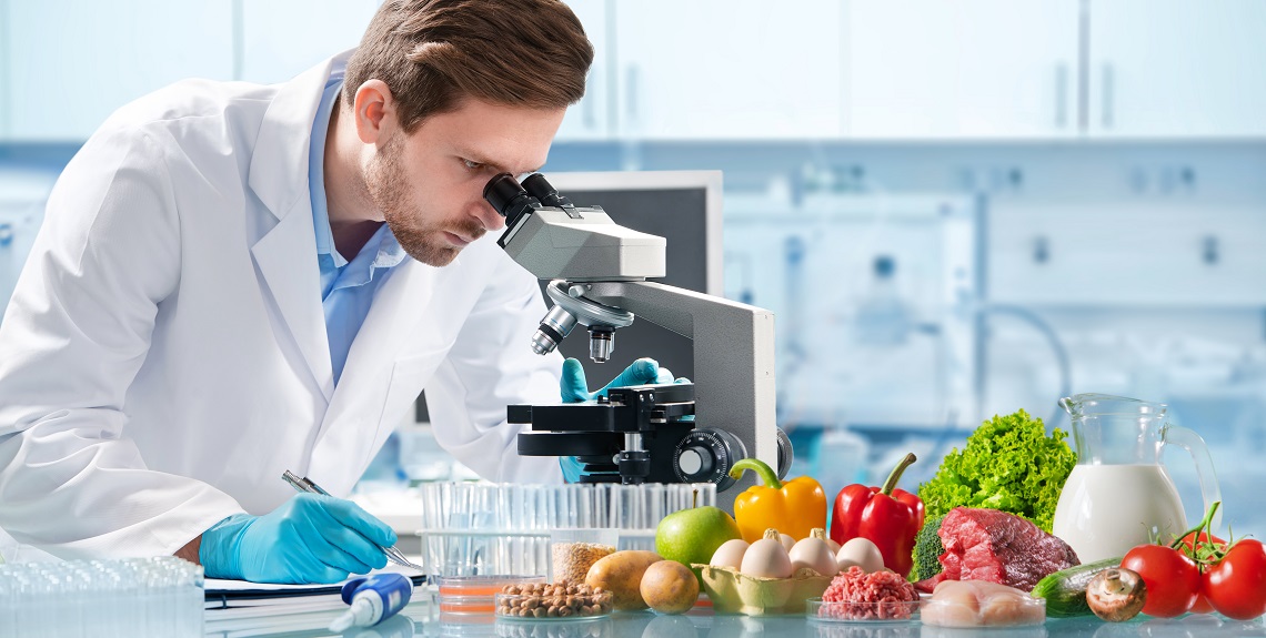 Lab researcher and display of food types relating to food safety