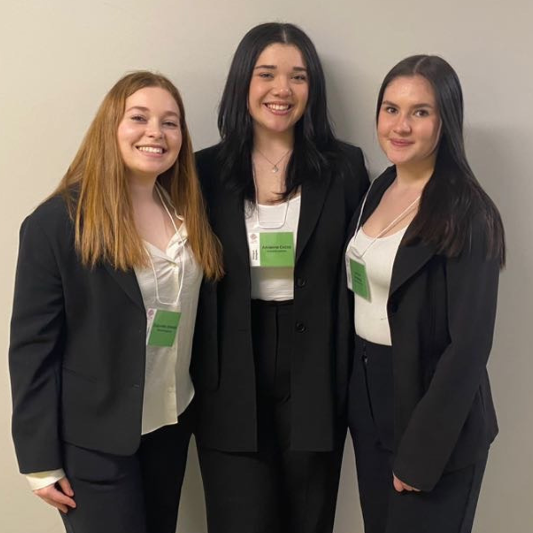 Three students smiling after winning an award