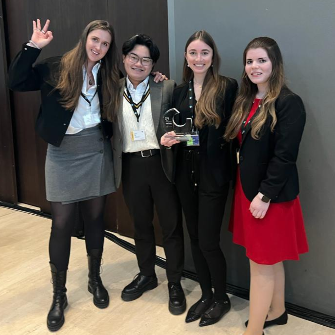 Four students standing excited about winning an award