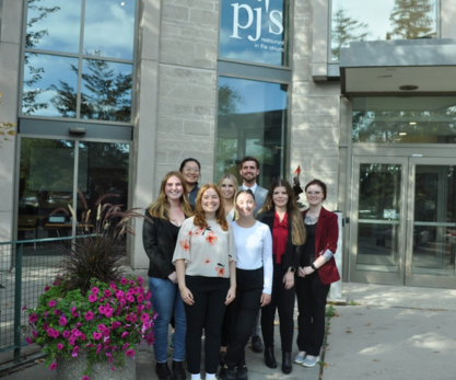 Eight students standing in front of MacDonald Stewart Hall