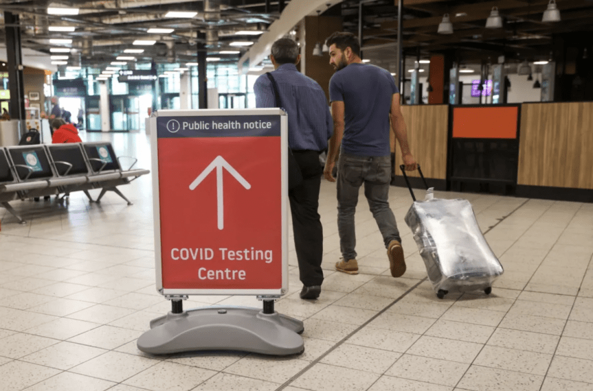 Photo of two people pulling luggage through airport terminal