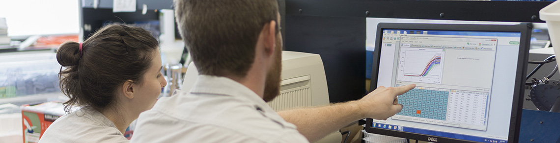 A photograph of two students looking at a computer screen.