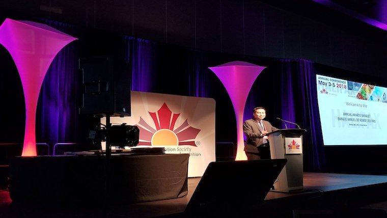 A photograph of Dr. David Ma speaking as President of the Canadian Nutrition Society
