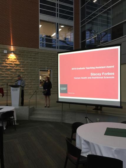 A photograph of Stacey Forbes accepting her award.