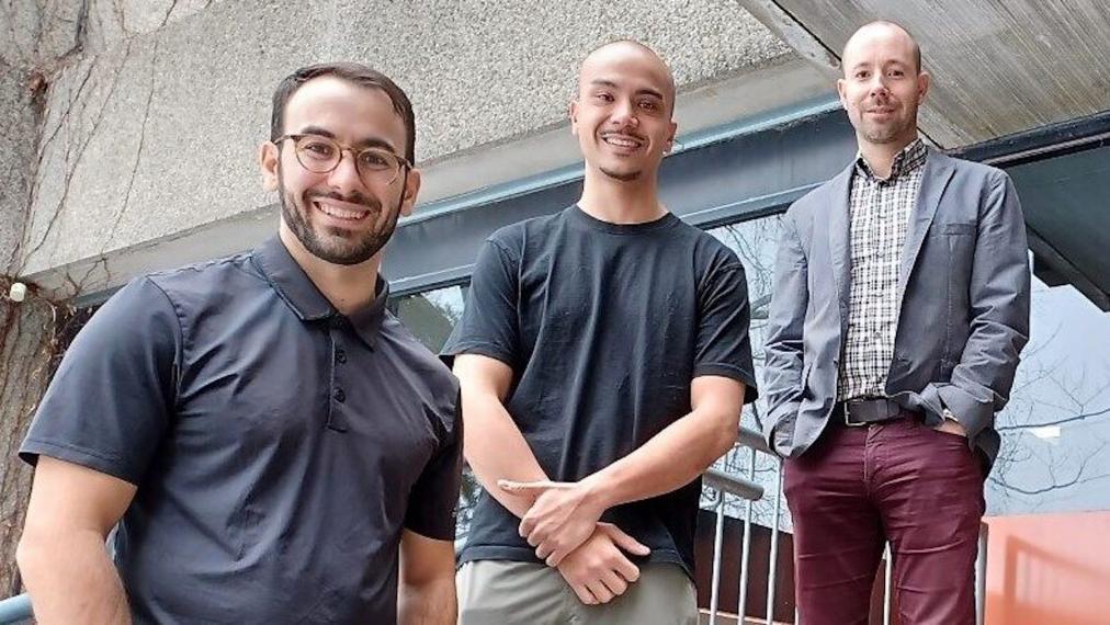 A group photo of three of the researchers involved in the study on the stairs of the Human Health & Nutritional Sciences' loading dock.  From left to right - PhD candidates Massimo Nardone and Christian Cheung; Dr. Philip Millar