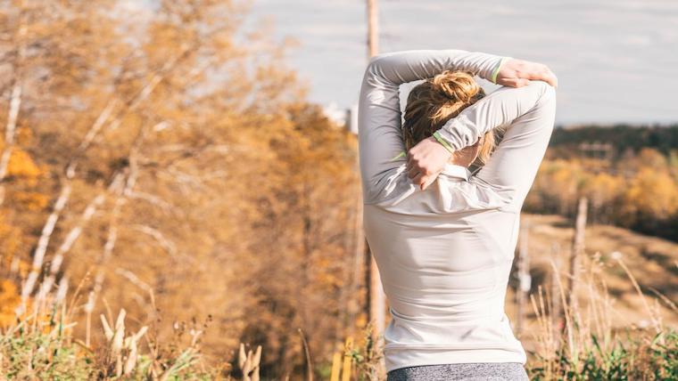 A photograph of a woman stretching.