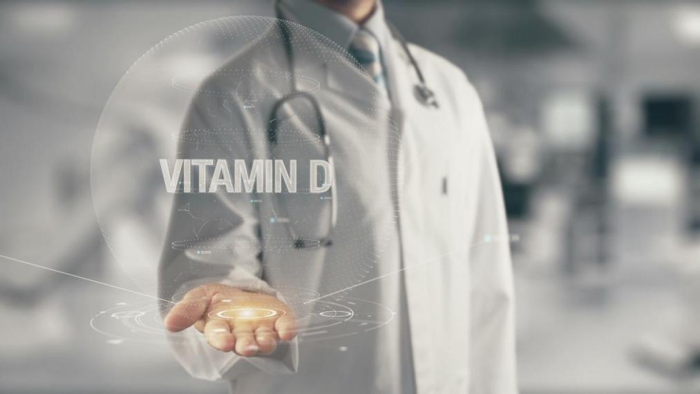 An image of a scientist in a lab coat with the title Vitamin D