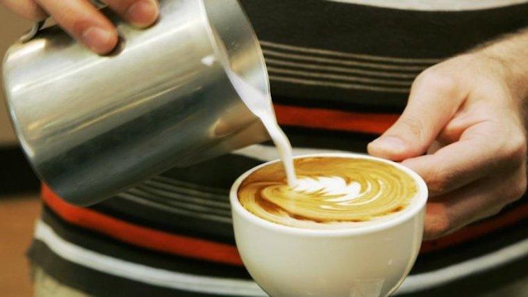 a barista pouring a cup of café au lait