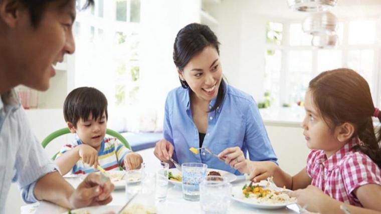 A photograph of a family eating a meal they prepared together