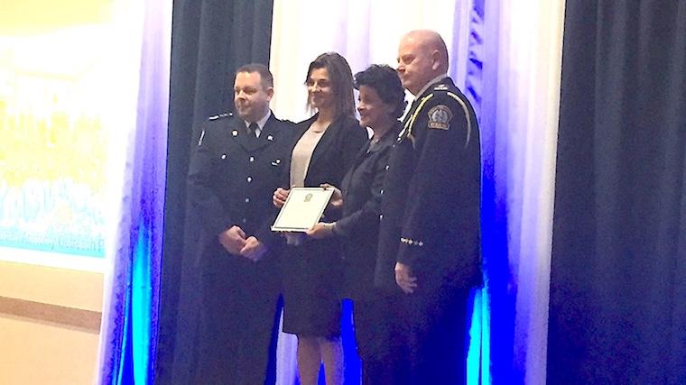 A photograph of Dr. Lorraine Jadeski and Premila Sathasivam being presented with a plaque by two paramedics