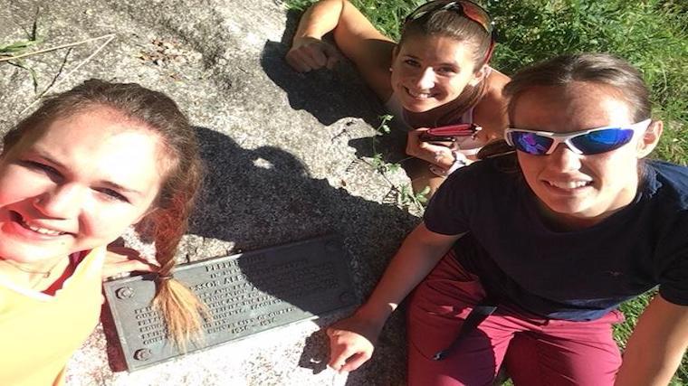 A photograph of the first crew to find Dr. Peere's memorial, posing with the plaque