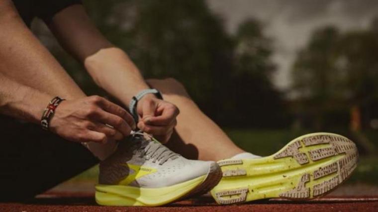 A photograph of a person tying their running shoe.