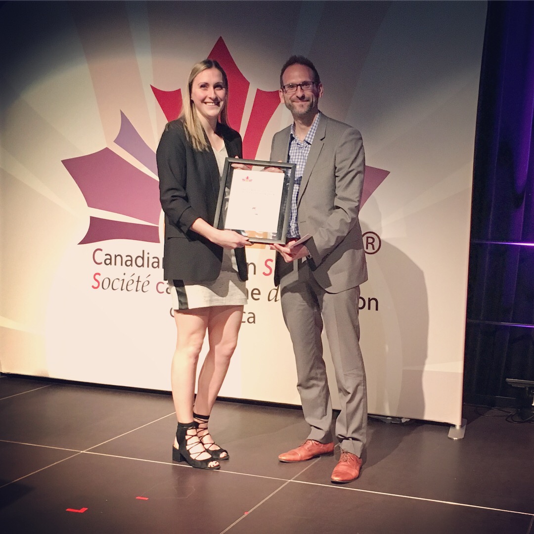 A photograph of Brittany MacPherson receiving an award from Dr. David Mutch