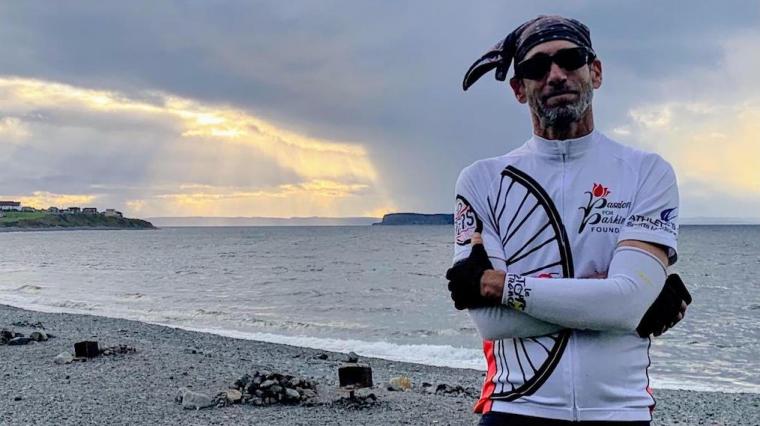 Steve Iseman wearing bicycling attire on the shore.