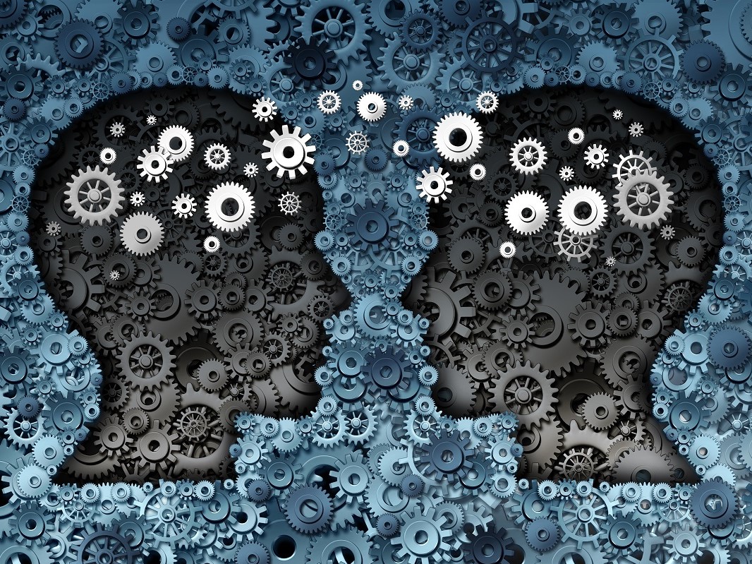 Silhouettes of two heads facing each other with a background filled with cogs.