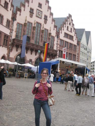 Stephanie poses in front of an old German building in a square.