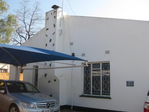 White washed cement building with a blue awning. 