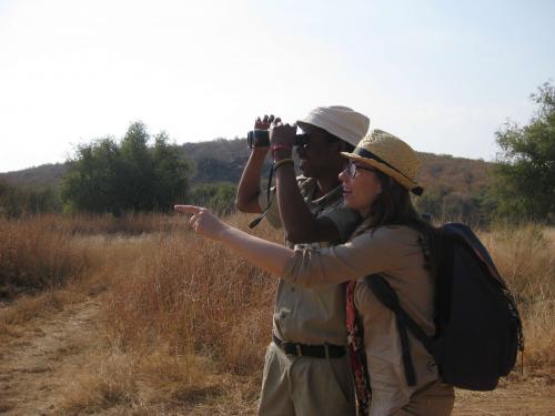 Stephanie points and guide looks in same direction with binoculars. 