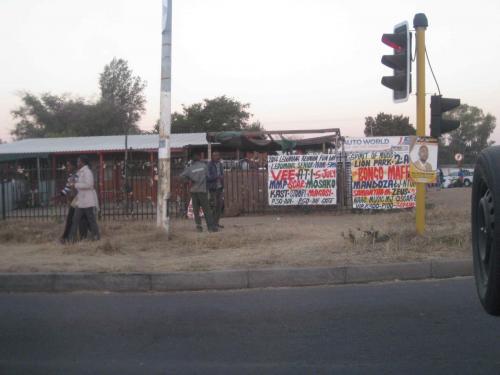 Hand written signs in Setswana at a road corner