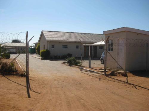 Dirt entrance leads into centre with small white building