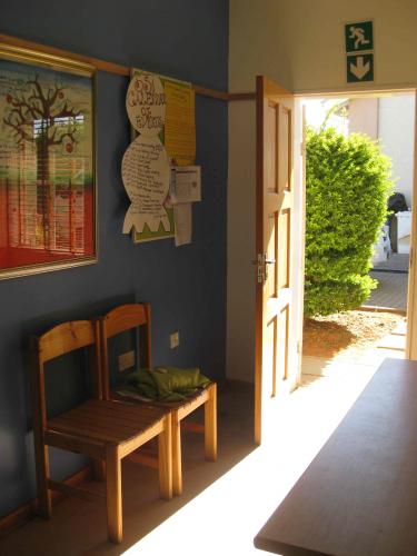 Room leading to door outside, blue wall is covered with drawings and paintings