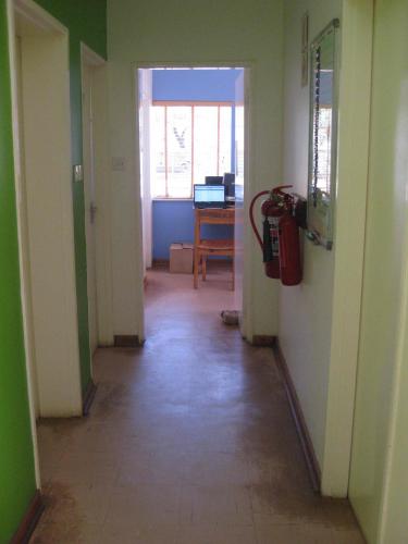 White hallway leads to room with an open door and computer inside