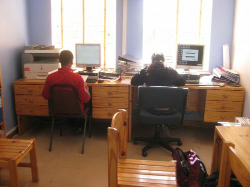 Male and female sit at desks working