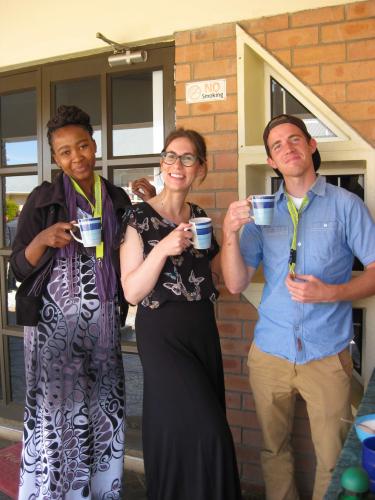 Lyan, Stephanie and Garret smile with tea mugs in their hands