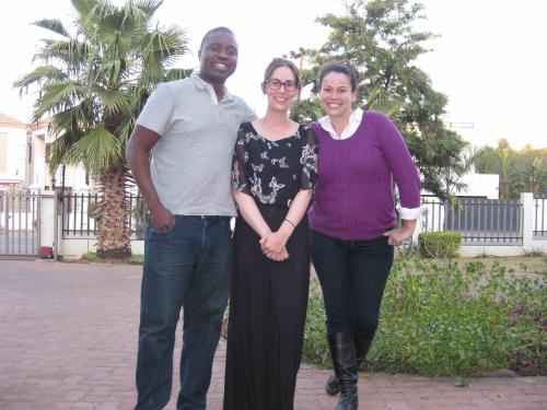 Isaac, Stephanie and Lia pose outside together. Palm trees in the background.