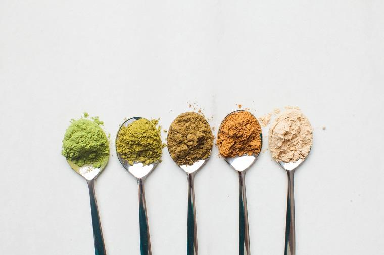 Spoons of different coloured protein powders