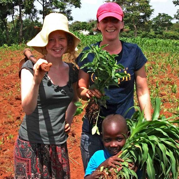 Nat and Kiera in Kenya with a little kid helping in the fieldwork